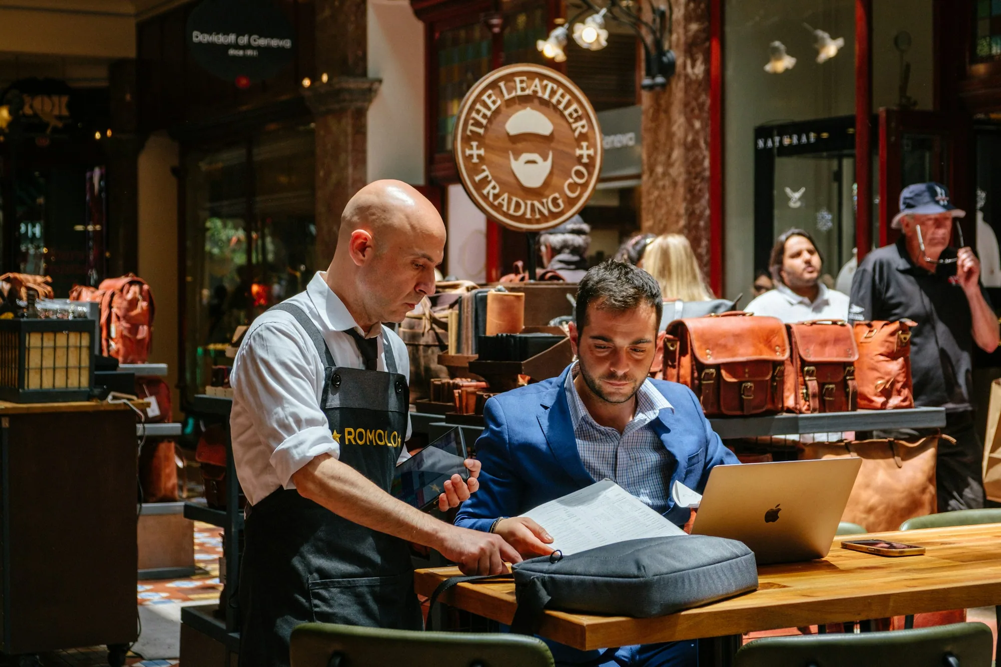 Two colleagues reviewing business records together at a counter.